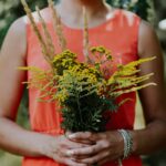 Kobieta z bukietem kwiatów łąka wrotycz żółte kwiaty